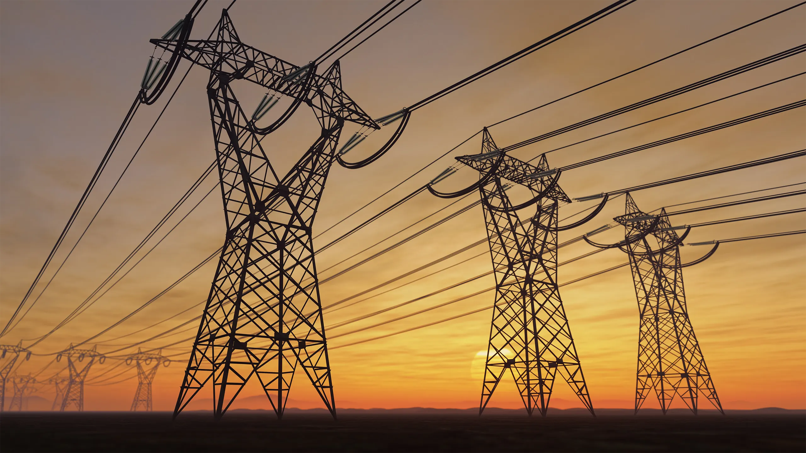 The silhouette of the high voltage power lines during sunset.
