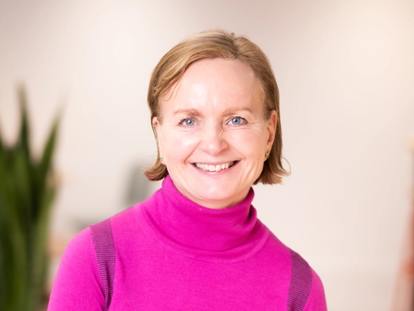 Portrait of Sarah Leaman, Global Corporate Communications Director, in an office with a plant in the background