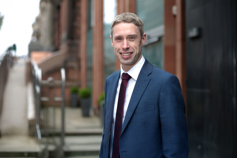 Portrait of Paul Convery, Director, Forensic Planning & Delay, UK, outside in front of brown buildings