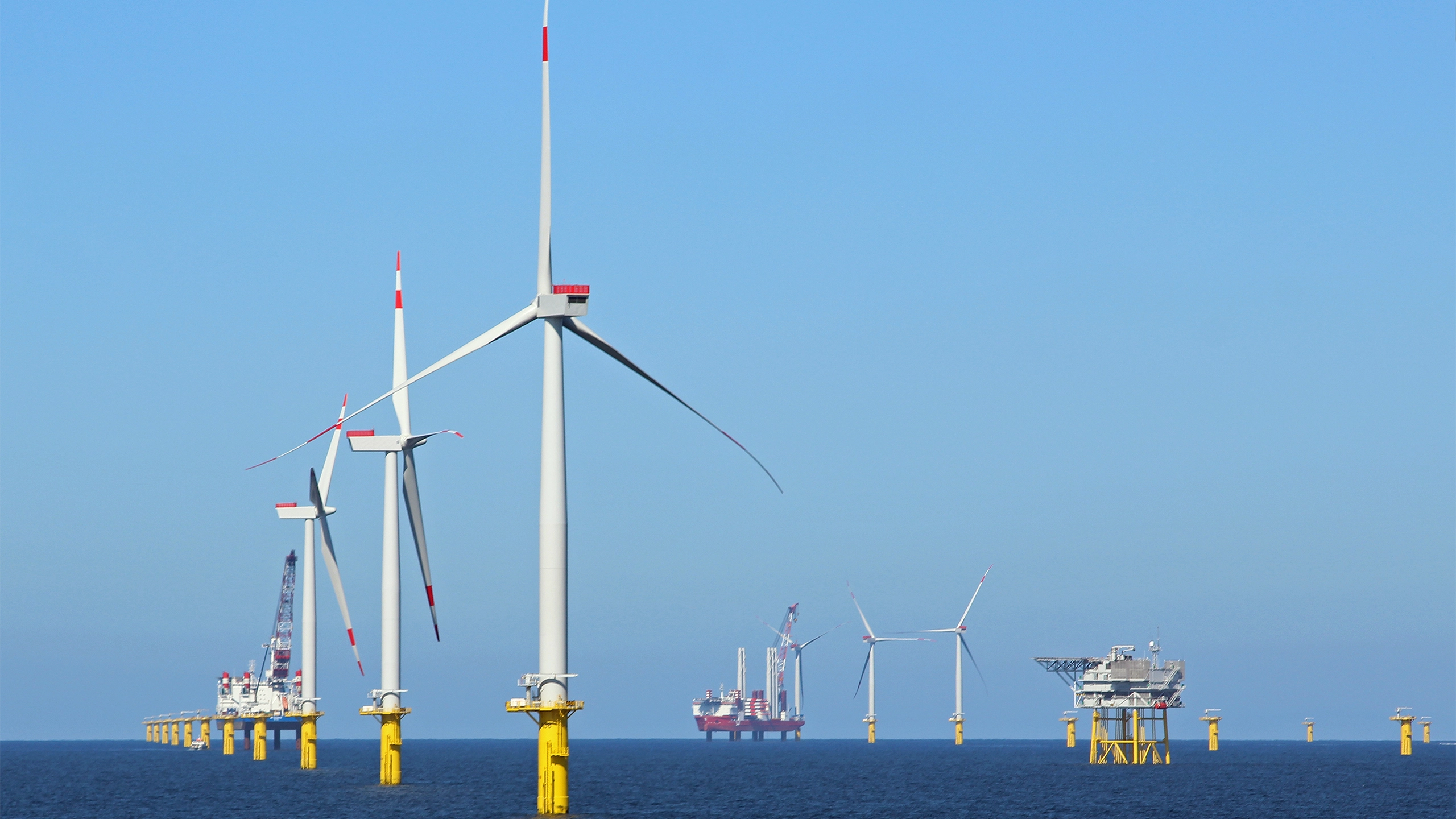 Multiple offshore wine turbines; daytime