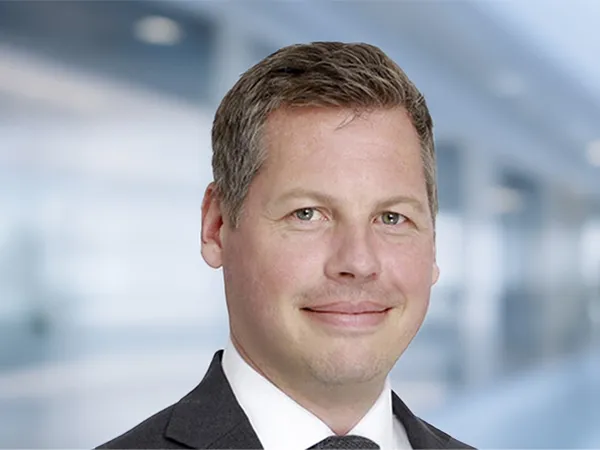 Portrait of Gavin Steele Director, Global Head of Aviation standing in blurred office background.