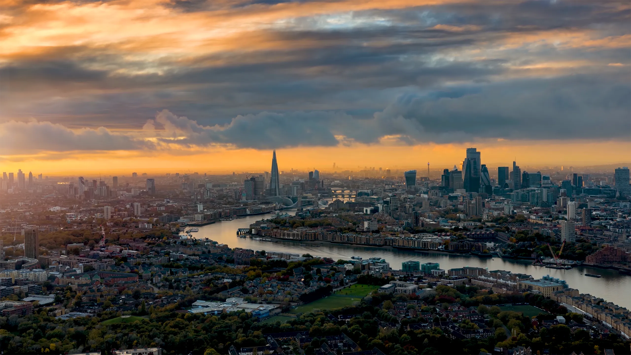 High panoramic view of the urban skyline of London, England, with the river Thames leading into the City disctrict and beyond during a beautiful sunset