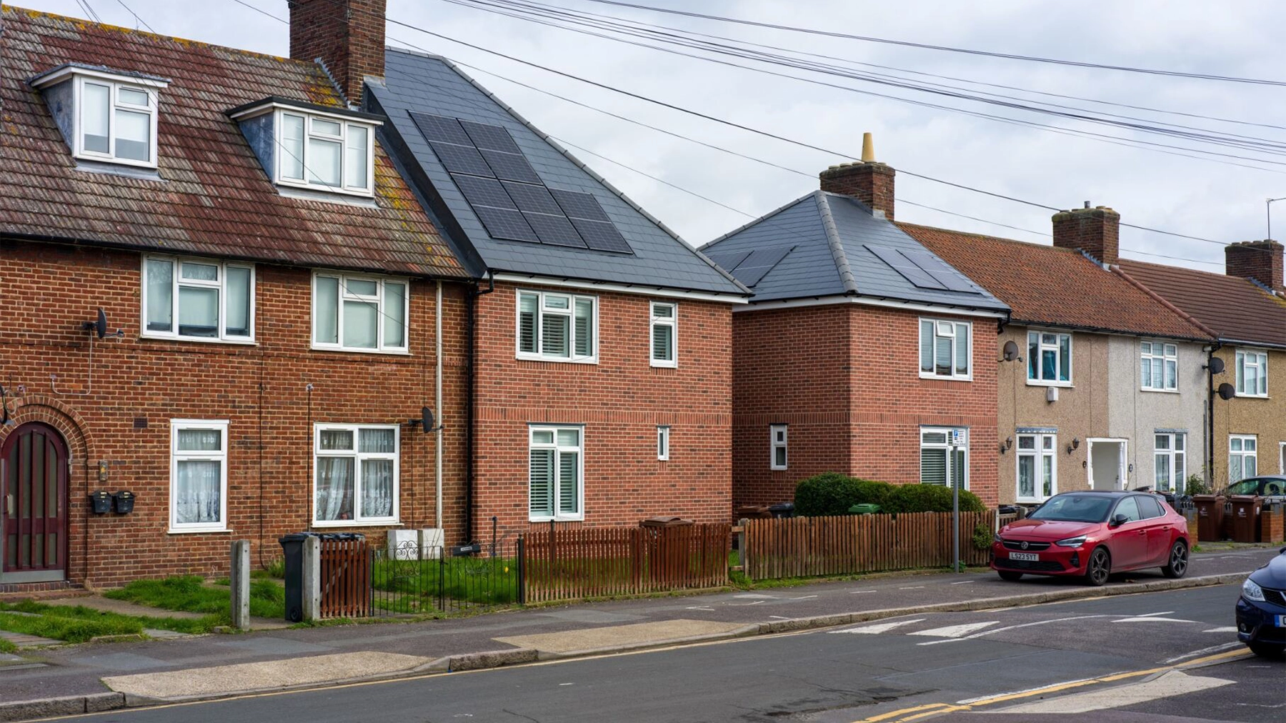 Brown houses on street with two houses that have solar panels on roof