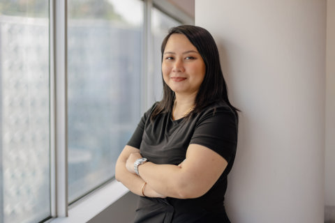 Portrait of Siti Norman, Director, Digital, Singapore, standing against white background and window.
