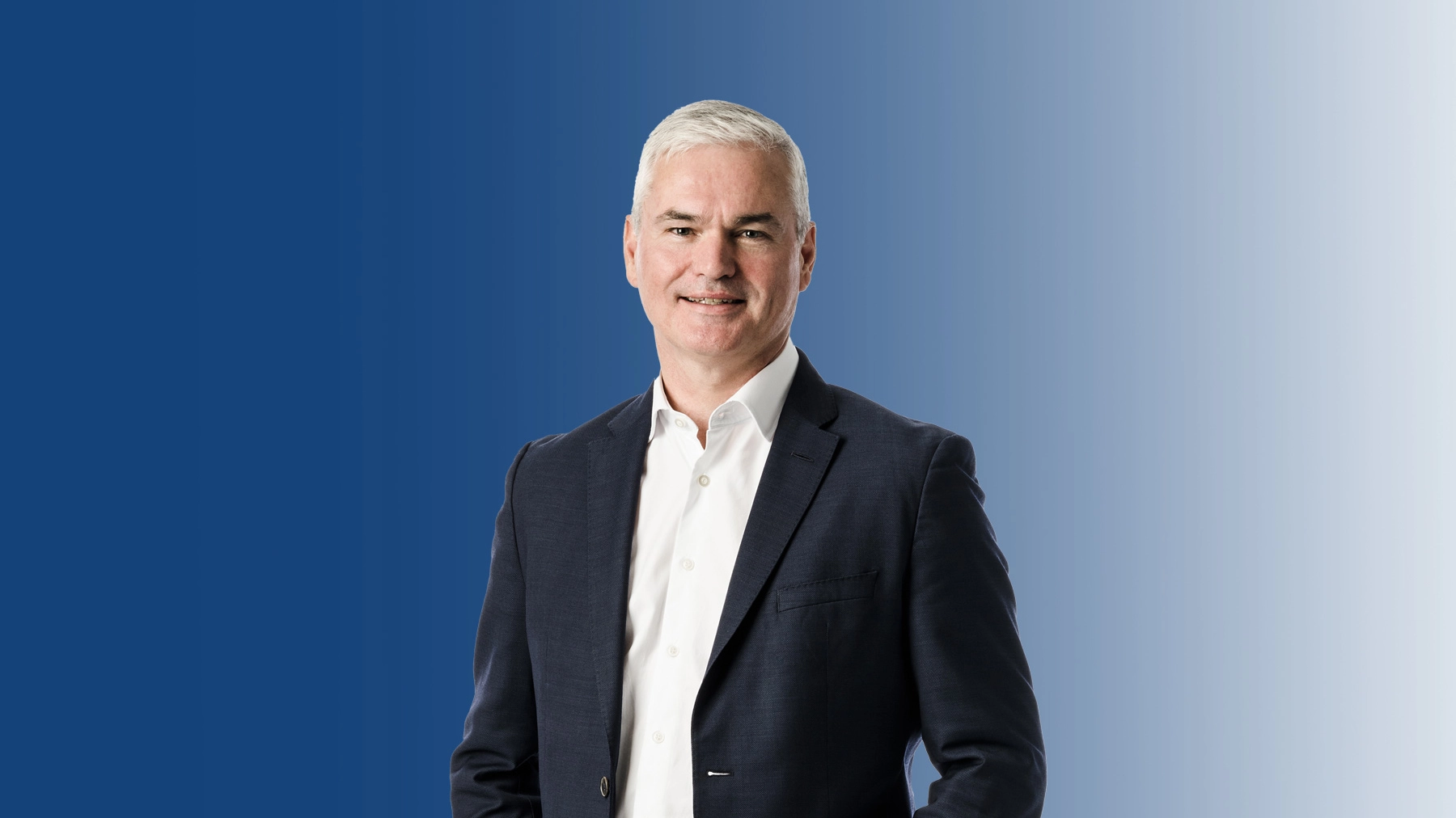 Portrait of Vincent Clancy smiling against a blue background