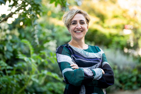 Portrait of Nadia de Klerk, Director, Global Head of Occupier & Retail, outside in front of a garden.