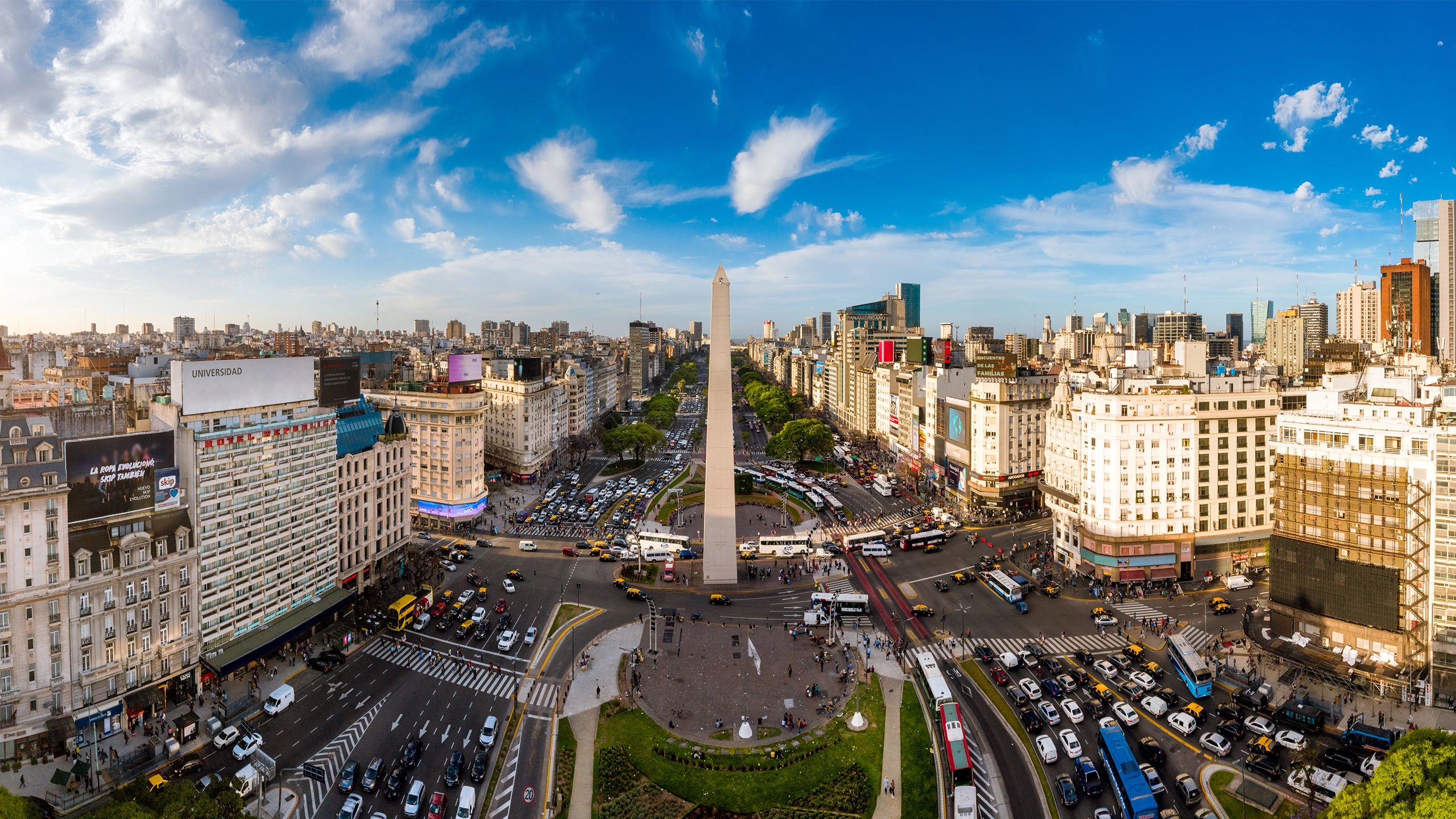 Skyline view of Buenos Aires with lots of cars on the road and tall monument in the middle 