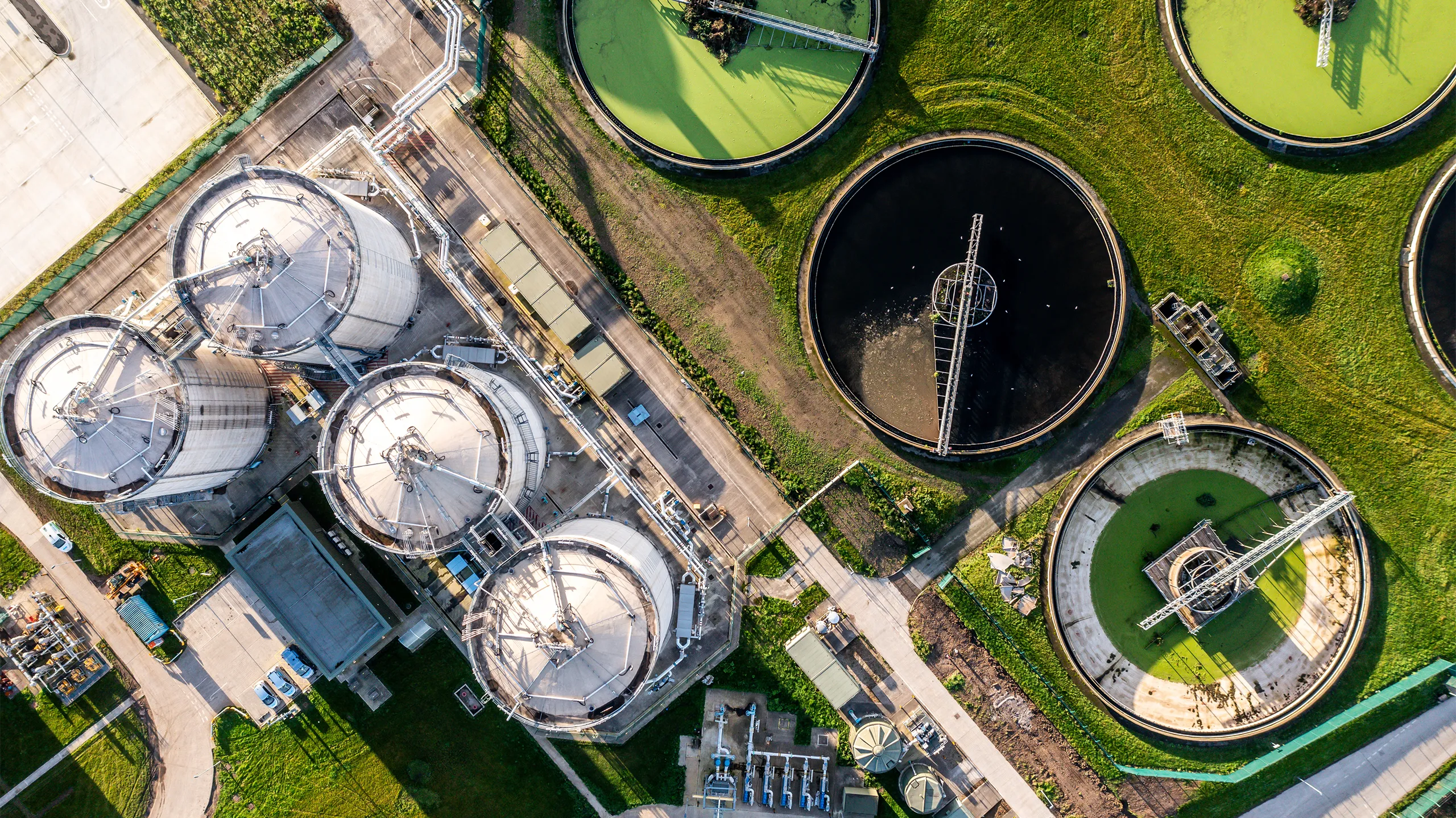 An aerial view directly above a waste water treatment works with circular storage tanks filtering wastewater for drinking water