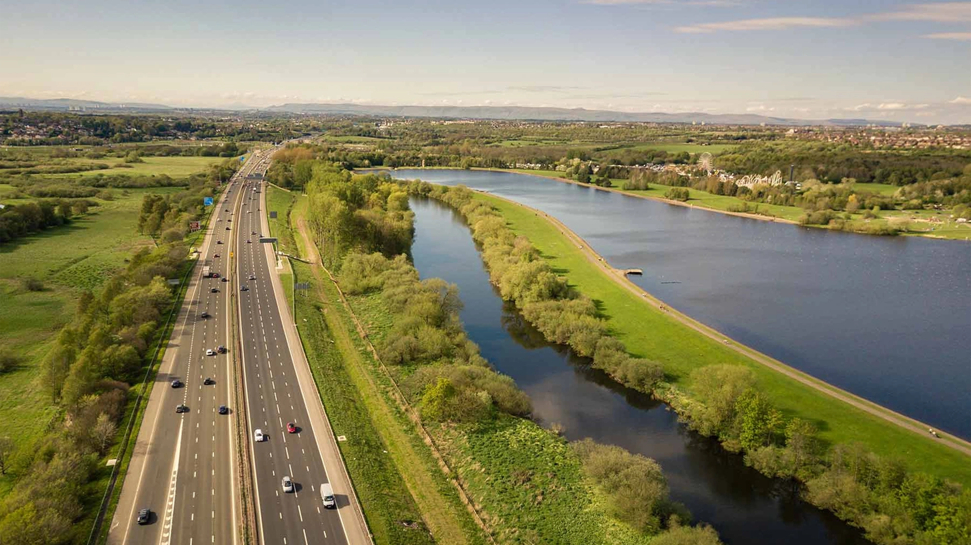 View of a motorway with greenery surrounding the motorway.