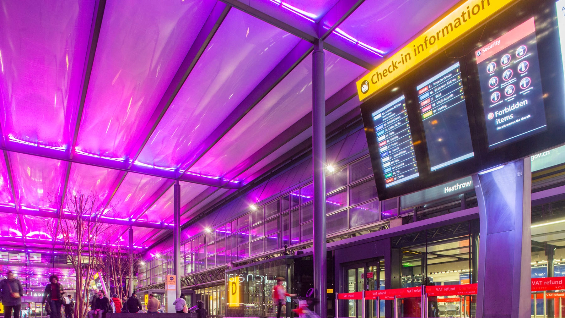 Airport terminal  with purple ceiling and check-in information board